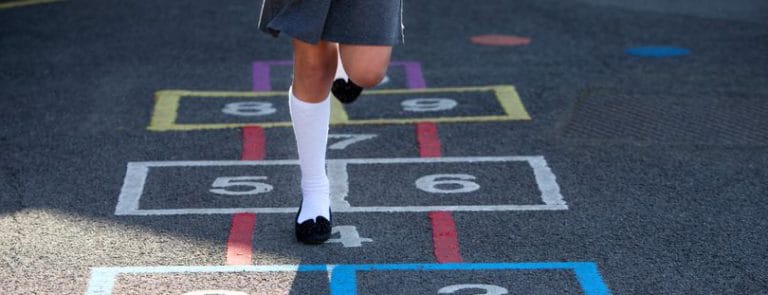 A girl playing hopscotch in a playground