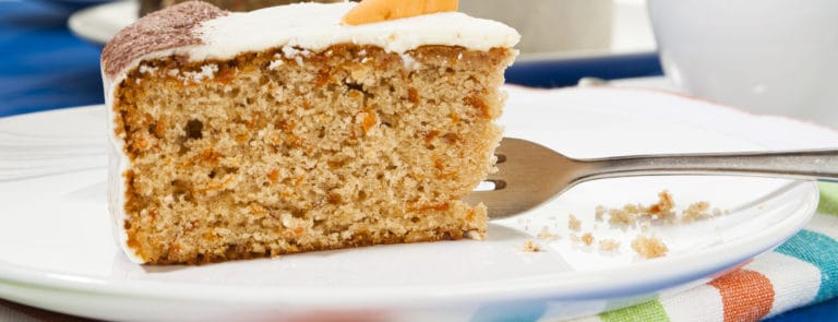 Piece of carrot cake and fork on a plate
