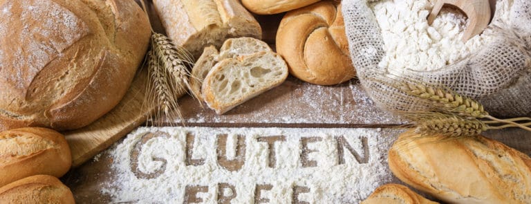 Gluten free spelt out in flour with bread loaves around it