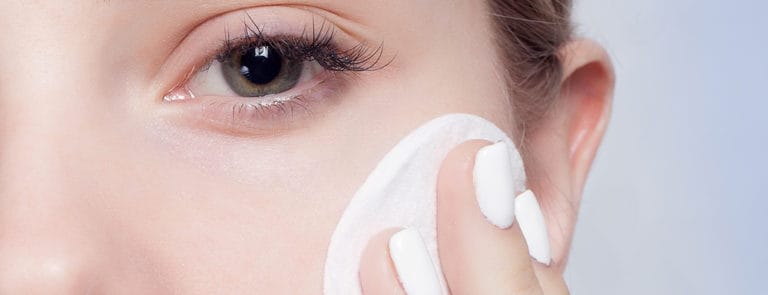 A women wiping make-up off her face close up