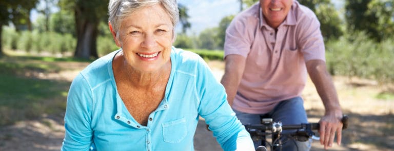 An elderly couple riding bicycles