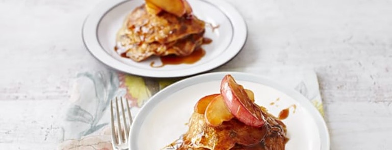 Two plates with raisin pancakes with caramelised apples