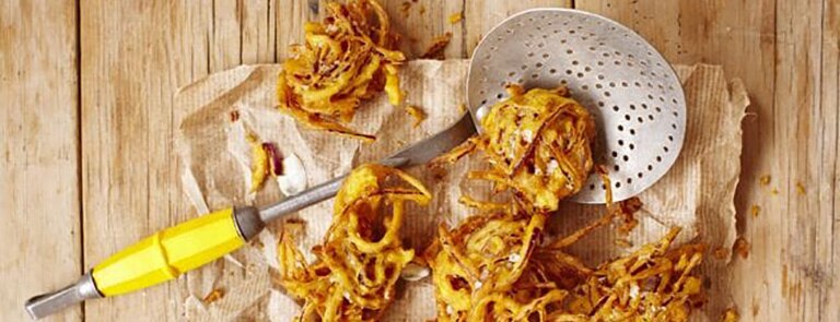 Red onion bhajis with mint dip on parchment paper