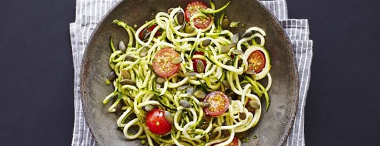 A bowl of courgette spaghetti with nut free spinach pesto