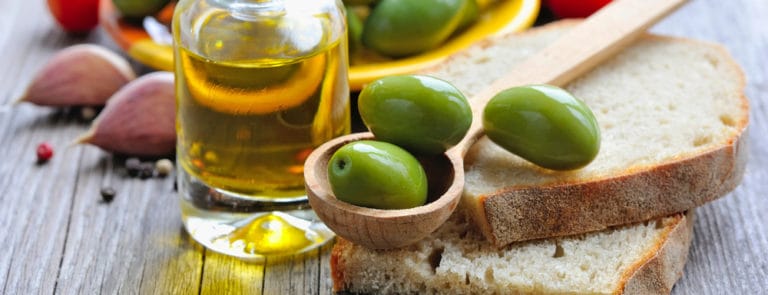 Jar of Olive Oil with bread, olives, tomatoes and garlic