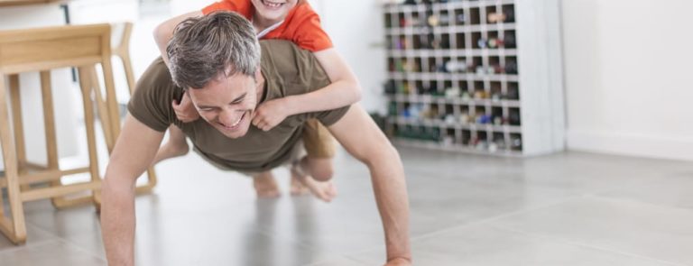 A dad doing Press ups with his son on his back