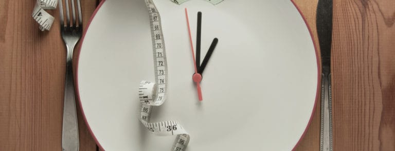 A scale with a clock on and a tape measure