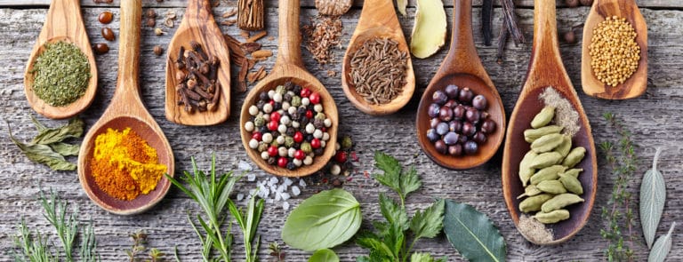 Wooden spoons with various seeds, lentils, beans and powders on them