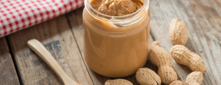 Creamy peanut butter on wood table.