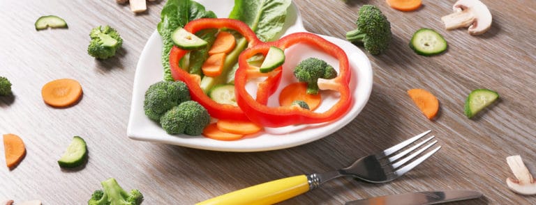 Useful cut vegetables on a plate in the form of heart
