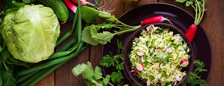 Vitamin salad of young vegetables: cabbage, radish, cucumber and fresh herbs.
