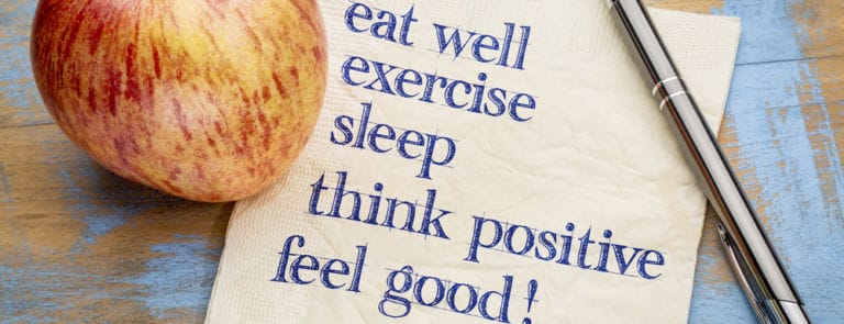 Think positive , exercise, eat well, sleep - concept of feeling good - handwriting on a napkin with an apple