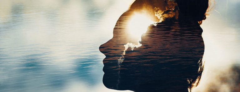 Transparent silhouette of woman's head in front of a river