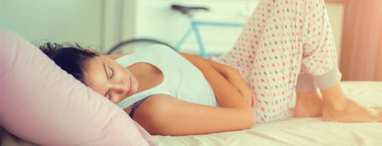 Women lying on bed, wearing pyjamas