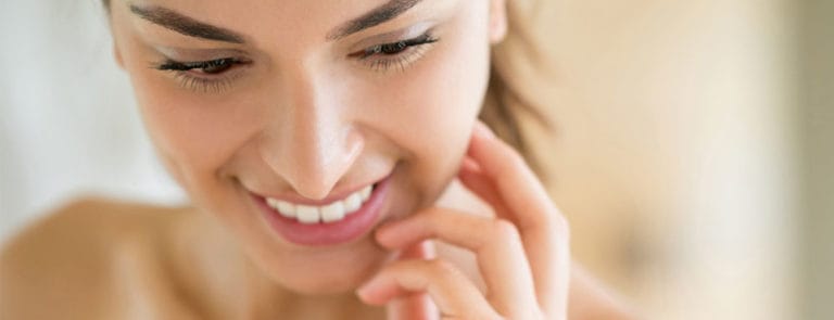 Woman smiling with hand on face