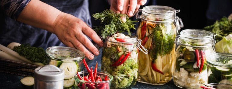 a woman fermenting foods in glass jars