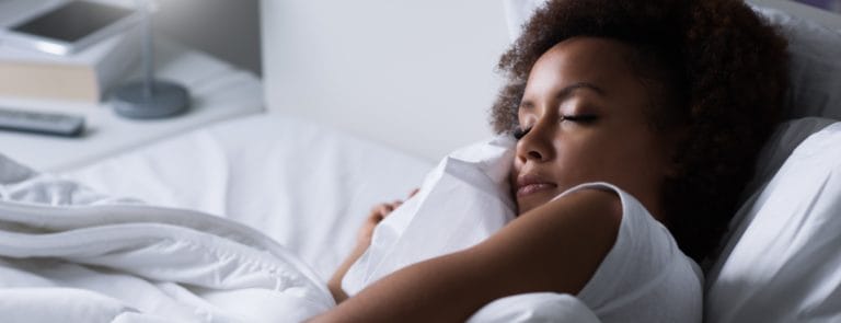 Women sleeping on grey pillow in bed 
