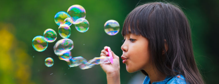 a child relaxing by blowing bubbles