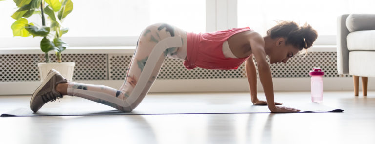 woman doing a push up at home to strengthen her upper body