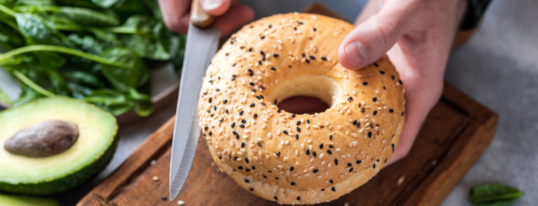 man slicing a healthy bagel as part of a balanced diet