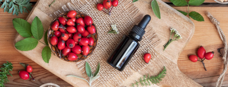 a bottle of rosehip oil and rosehips