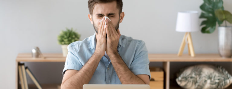 man sneezing a sign of hay fever