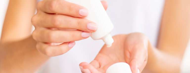applying cream to hands to treat contact dermatitis