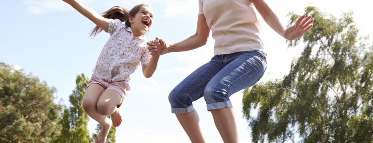mother with daughter jumping on a trampoline filled with energy