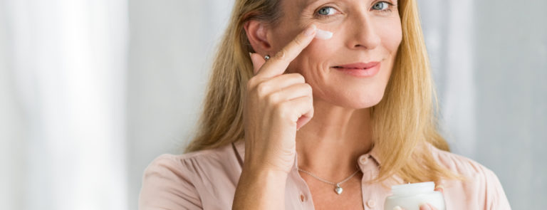 woman applying ageless beauty products to her face