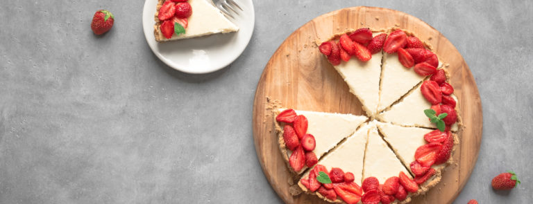 A vegan cheesecake, topped with strawberries.