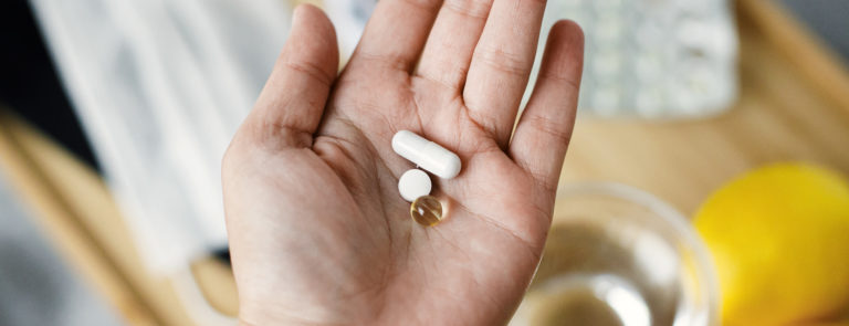 A hand holding supplement tablets