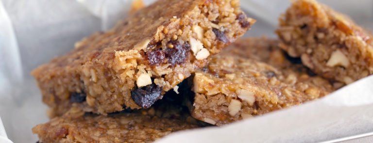 A flapjack with dried fruit and nuts inside, cut into squares.